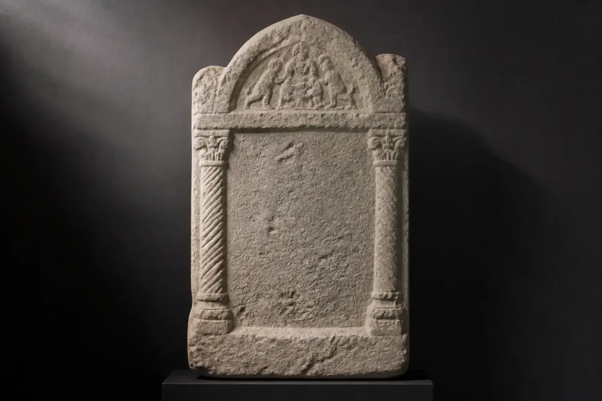 Stèle funéraire gallo-romaine en calcaire d'Aquitaine, aux reliefs usés, présentée dans un musée.