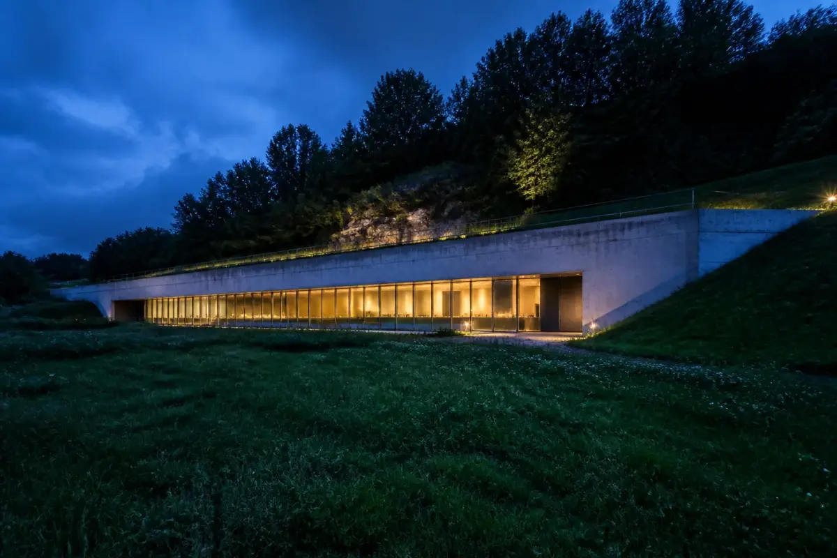 Façade de béton de Lascaux IV encastrée dans la colline de Montignac à la tombée du jour.