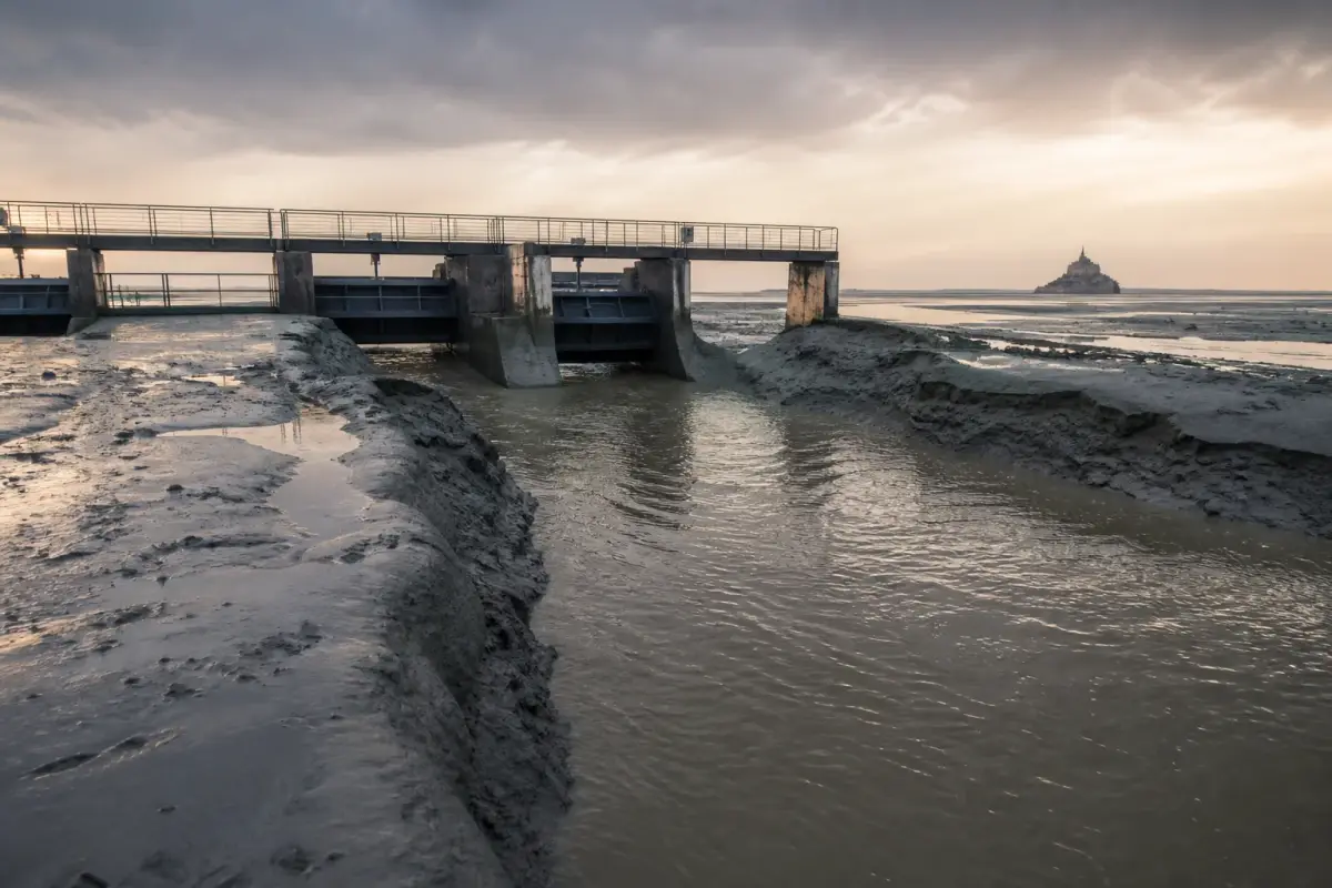 Barrage du Couesnon à marée basse, avec ses vannes d'acier et les bancs de sable de la baie.