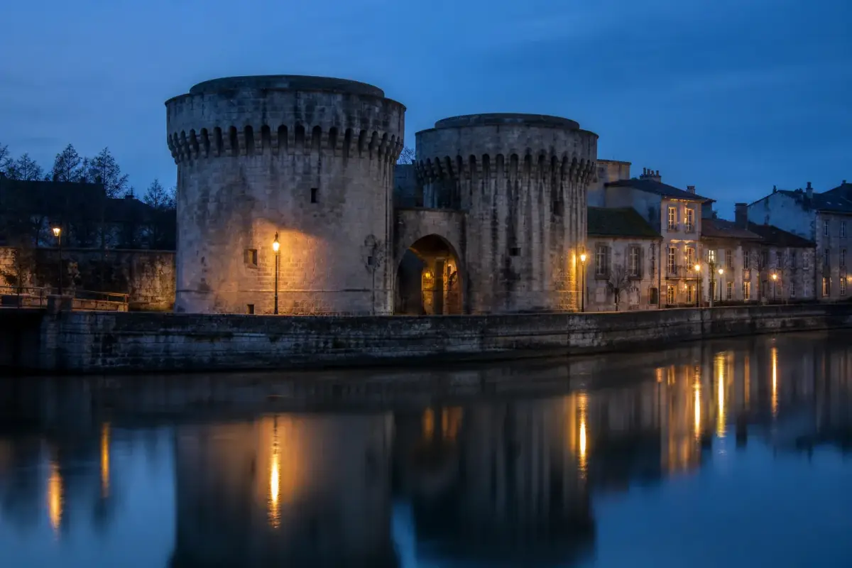 Les tours de la porte Chaussée à Verdun se reflétant dans la Meuse au crépuscule.