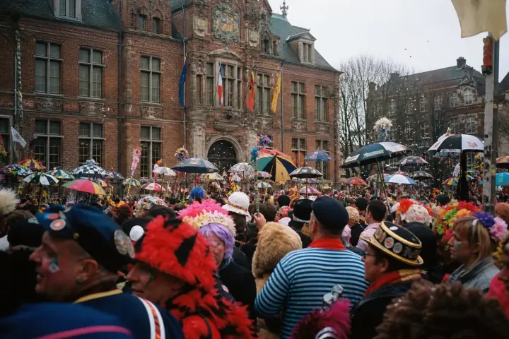Foule de carnavaleux déguisés et parapluies colorés levés devant l'hôtel de ville de Dunkerque lors du jet de harengs.