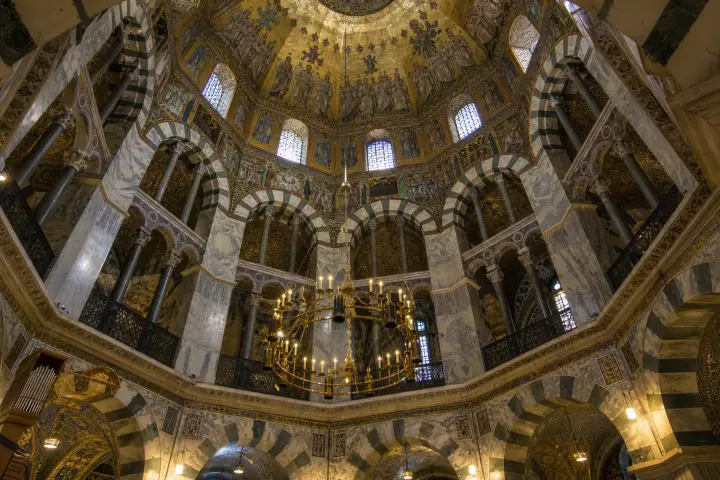 Intérieur de la chapelle palatine d'Aix-la-Chapelle avec son plan octogonal, ses arcades et ses mosaïques.