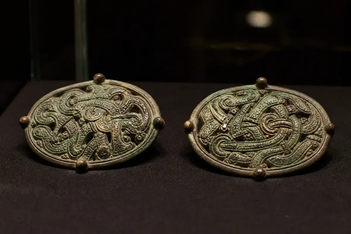 Deux fibules ovales en bronze de type scandinave présentées dans une vitrine de musée.
