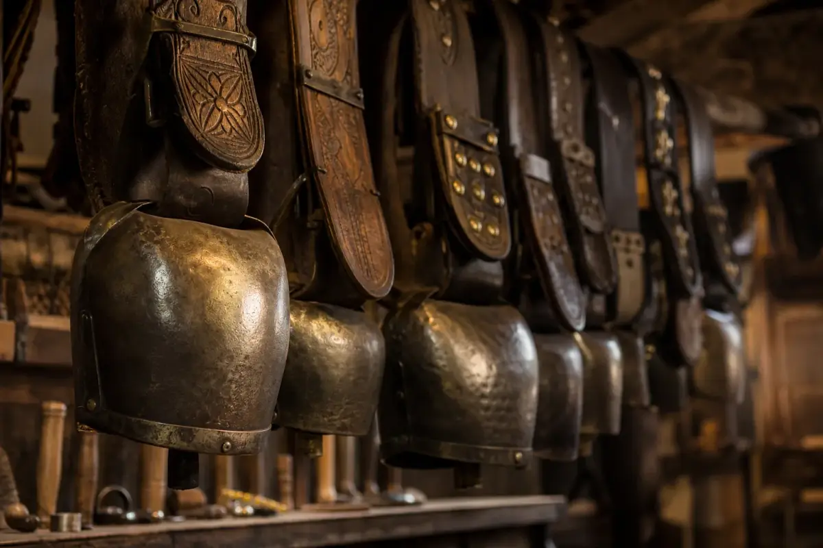 Sonnailles de tôle martelée suspendues à leurs colliers de bois dans un atelier béarnais.